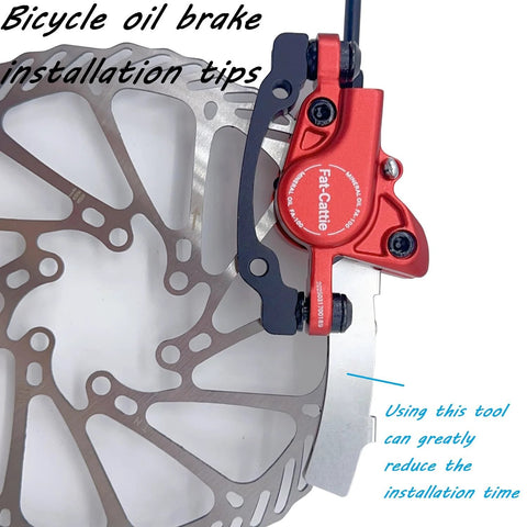 Front view: Fat-Cattie red hydraulic disc brake caliper with 160mm rotor mounted on a bicycle wheel