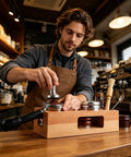 Premium 58 Mm Espresso Tamping Station Crafted From Warm Natural Wood, with a tamper and accessories on a coffee counter.