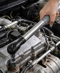 1/2 Inch Offset Extension Wrench Impact Rated Ratchet Adapter For Electric Drill in use on a car engine, showcasing a sturdy grip.