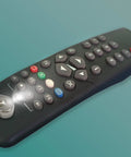 Ultra Compact Stick On LED Thumb Light attached to a TV remote, illuminating buttons with bright light