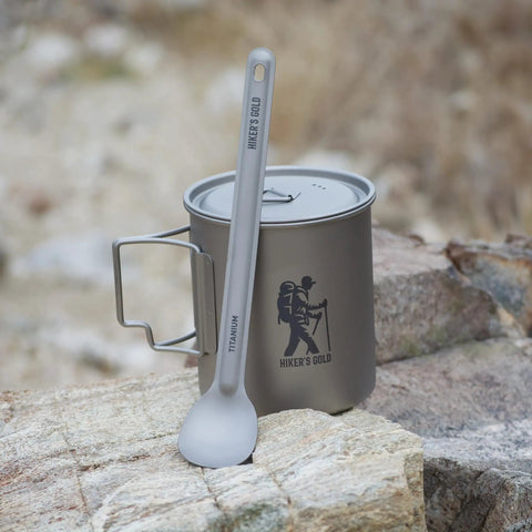 Ultralight Titanium Camping Spoon For Backpacking And Hiking, 16g Silver Utensil With 8.5 Inch Reach resting on outdoor stone