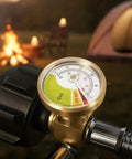 Close-up of gauge on stainless steel braided RV propane hose, showing gas levels for camper tanks, fire background.