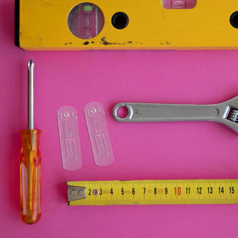 24 Pack Plastic Shelf Support Pegs For 0.79 Inch Thick Panels with tools and tape measure on pink background