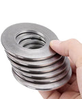 Ten Piece Bucket Pin Shim Kit For Excavators And Skid Steers, Fits 30 To 120 mm Pin Diameter, 1 2 3 5 mm Thick Shims, Tightens Loose Joints, Keeps Dust Out, Extends Grease Intervals, Beefed-Up Steel Construction, stacked steel shims in hand