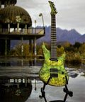 Electric guitar with lime-green marbled finish on a black stand outdoors by water.