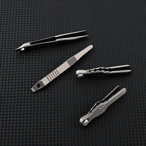 Alloy Pocket Tweezers For Camping And Hiking Gear on textured black surface, different designs shown for outdoor travel use.