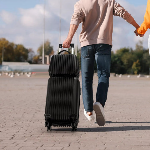 Two Piece Hardside Luggage Set With 20 Inch Carry On Spinner Suitcase And 14 Inch Stackable Travel Handbag ABS Durable Lightweight Trolley For 1 To 4 Day Trips TSA Friendly Jet Black being carried by a person walking outdoors