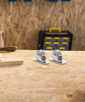 6-Piece Stainless Steel Pulley Roller With Bearing Set For Wall Mount Traction, Easy Install For Power Cables, Clotheslines, Rope Hoisting And Heavy Duty Cable Management. Two stainless steel pulley rollers on a workbench.
