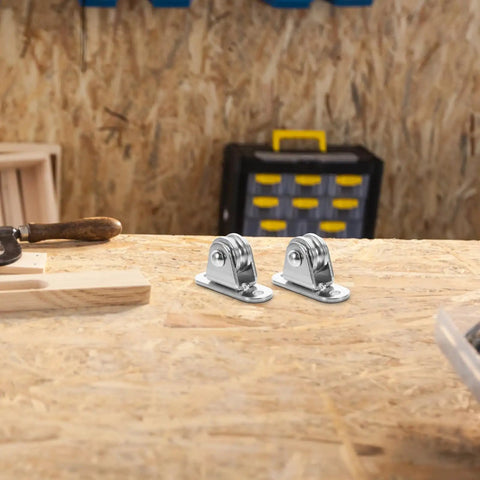 6-Piece Stainless Steel Pulley Roller With Bearing Set For Wall Mount Traction, Easy Install For Power Cables, Clotheslines, Rope Hoisting And Heavy Duty Cable Management. Two stainless steel pulley rollers on a workbench.