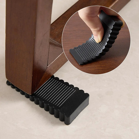 Rock Solid Black Rubber Wedge Shims For Furniture Leveling Hella Sturdy Anti Slip Wobble Pads placed under a table leg.