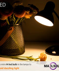 Tiny Reflector LED Bulbs For Curio Cabinet Lighting 40W Equivalent 2700K illuminating a desk lamp beside flowers at night.