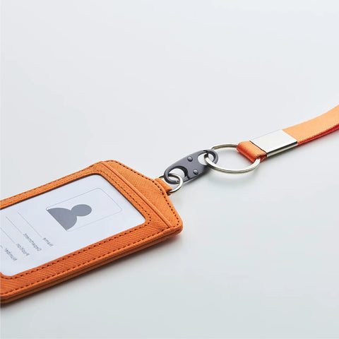 Orange ID card holder with lanyard, featuring a metal ring and clip attachment, shown against a white background.