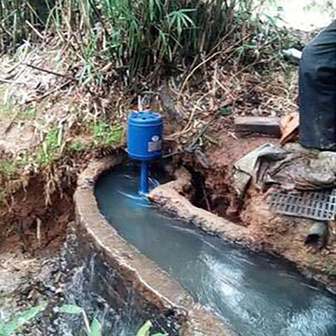 Installed Ready-To-Go 3KW Single Phase Axial Flow Hydroelectric Generator Kit 220V Water Power Generator along a river path.