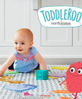 Baby playing on colorful mat with Toddleroo logo, suitable for Wall Mount Kit For Baby Play Yards Extends Your Superyard Across Wide Open Spaces.