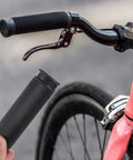 Person holding 4 Pack Bike Handlebar Grips Replacement Grippy Rubber Anti Slip for Mountain Bikes next to installed grip on bike