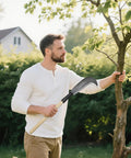 Man trimming tree with 22 Inch Steel Machete For Heavy Duty Yard Work And Tree Cutting Beast Ready All Purpose Garden Clearing Tool With Wooden Handle Pruning Trimming Harvesting Tall Grass And Rugged Carbon Steel Blade
