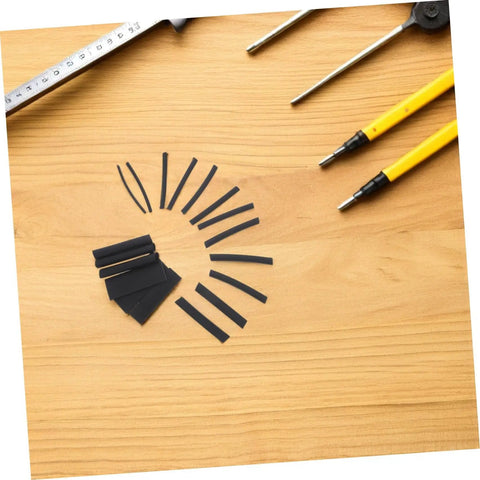 Grab This Insane Heat Shrink Tubing Polyolefin Kit For 900 Black Cables And Wiring To Keep Your Electric Gear Looking Fresh And Protected From Damage. Black polyolefin heat shrink tubing pieces on a wooden table