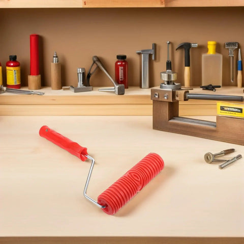 Knockout 2 Piece Wood Grain Texture Paint Roller Pair Featuring Rock Solid Grip Handle For Quick Drywall Mud Work And Real Deal Fake Timber Finish Results That Truly Stand Out resting on a workbench with other tools.