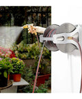 Heavy Duty Wall Mount Garden Hose Reel With Removable Hose Box For Outdoor Yard Tidying Quick Rewind Storage Up To 131 Feet installed in garden with hose in use.