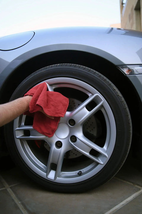 Person using 150 Pack Cotton Shop Towels Rags 14x12 Inches Absorbent, Reusable Cleaning Rags for polishing a car wheel