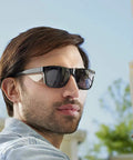 Man wearing Maverick Safety Glasses With Integrated Side Shields 3 Pack Smoke Anti Fog Lenses for eye protection outdoors.