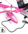 Pink RC Helicopter For Kids And Beginners 2.4GHz 3.5 Channel Indoor Flight Toy being charged via USB from a laptop