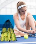 Six Colorful Mesh Drawstring Bags Set 14x18 Inch For Gym Gear Laundry Beach And Toys next to a woman tying her shoes on a tennis court.
