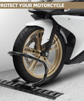 Motorcycle front wheel secured in black E-Track wheel chock on concrete floor, front view