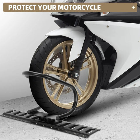 Motorcycle front wheel secured in black E-Track wheel chock on concrete floor, front view