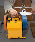 Dual Wheel Knife Sharpening System With 10 Inch 220 Grit Wheel And 8 Inch Leather Honing Wheel in use, restoring a knife edge.