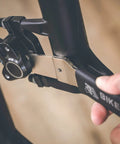 Two In One Disc Rotor Truing Fork And Caliper Piston Press Spreading Tool Wrench And Ratchet For Bike Maintenance And Brake Caliper Repair Suitable For Shimano SRAM And Other Disc Brakes Professional Grade Durable Steel being used on a bike brake caliper
