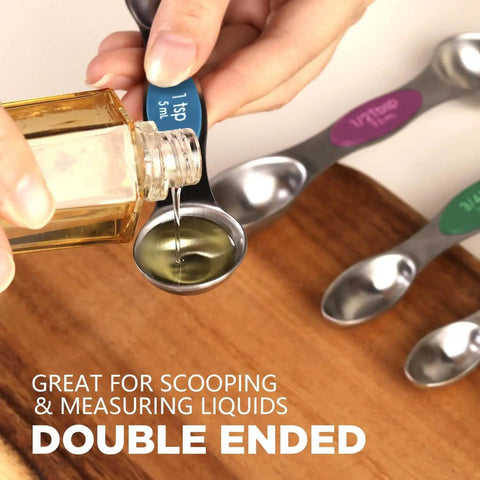 Person using Stainless Steel Magnetic Measuring Spoons Set Eight Piece Dual Sided And Stackable Teaspoon And Tablespoon Measures With Leveler Adjustable For Precise Cooking And Baking Kitchen Gadgets to pour oil
