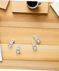 6 Piece White Nylon Sliding Wheels For Furniture Drawers Slick Rolling Track Guide Casters on wooden table with coffee cup.