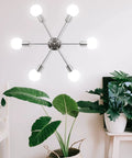 Six Light Sputnik Ceiling Light Fixture in nickel on white wall above plants, for kitchen dining room living space modern mid century style.