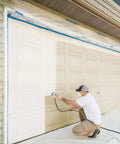 Person using a Heavy Duty Mobile Airless Paint And Stain Sprayer Cart to paint a garage door for smooth finishes.