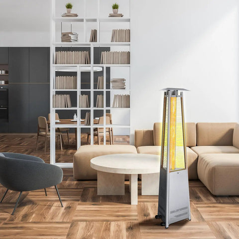 Modern living room with a four-sided pyramid flame patio heater beside a beige sofa and round table. Bookshelves in background.
