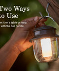 Person using Rechargeable 800 Lumen LED Lantern With Carabiner Handle And USB C Charging Ports For Camping Power Outages And Emergencies.