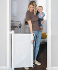 Parent with child using Retractable Baby Gate For Stairs And Doorways, Extra Wide Mesh Safety Gate For Kids And Pets, Easy One Handed Operation