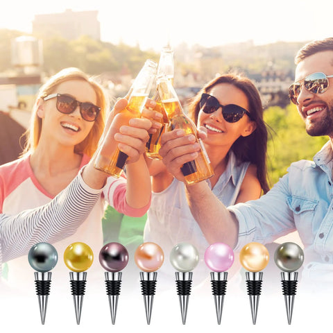 Front view of eight stainless steel wine bottle stoppers with colored metal ball tops and ribbed bases.