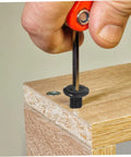 Person using hex key to tighten steel bolt in wooden panel from Bulk 170 Piece Steel Furniture Hardware Kit Rock Solid Screws And Nuts.