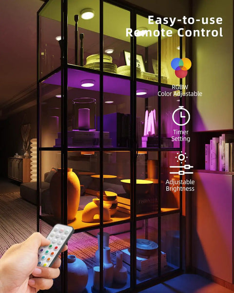 Rechargeable Motion Sensor Puck Lights 4 Pack RGB Under Cabinet Lighting With Remote illuminating a showcase display.