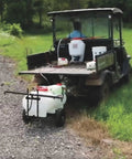 Tow Behind ATV UTV Spot Sprayer With 25 Gallon Dual Water And Concentrate Tanks, 12V Pump, in use on grassy terrain