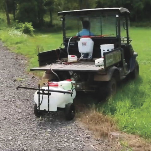 Tow Behind ATV UTV Spot Sprayer With 25 Gallon Dual Water And Concentrate Tanks, 12V Pump, in use on grassy terrain