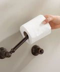 Hand placing toilet paper on Kingsley Chrome Double Post Pivoting Toilet Paper Holder Wall Mount For No-Fuss Install, Traditional Style