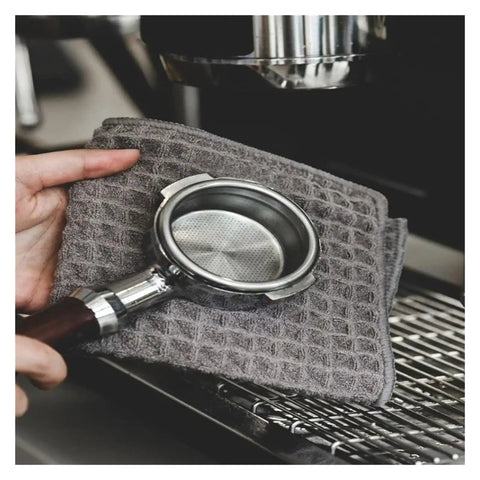 Hand holding portafilter with Barista Cleaning Cloth Set For Coffee Machines And Espresso Equipment Non Shedding Absorbent Towels 5 Pack Pro Grade For Home Cafe And Coffee Shop Cleaning Everyday on espresso machine