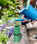Fix Your Garden Hose Quick With Expandable Repair Kit For 5/8 And 3/4 Inch Water Lines, Dual Channel Green Plastic Connectors For Fast Fixing Long Lasting Yard Systems From 25 To 100 Feet Of Hosing. Green plastic hose repair connector on watering can and garden bed