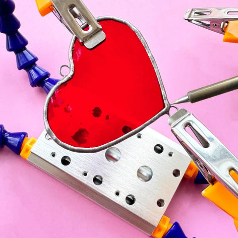 Soldering Clamp For Stained Glass And Jewelry Making, Adjustable Pro Grade Helping Hands holding a red stained glass heart.