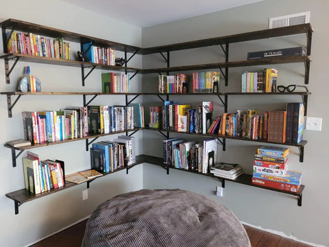 Room with wall-mounted floating shelves using Beefy 12 Inch by 8 Inch Heavy Duty Shelf Brackets 600 Lb Per Pair Black Metal L Brackets.