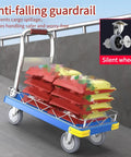 Heavy Duty Platform Hand Truck Featuring 360 Degree Swivel Wheels And Adjustable Safety Rail transporting colorful cargo bags on a smooth surface.