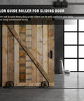 Rustic sliding wooden door with nylon guide rollers installed for smooth operation in industrial interior setting.